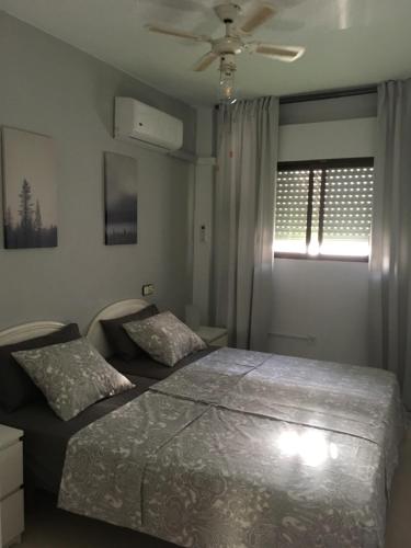 福恩吉罗拉Apartamento Trinidad mit Netflix的一间卧室配有两张床和吊扇
