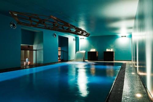 杜德尔斯塔特Zum Löwen Design Hotel Resort & Spa的蓝色墙壁的房间中的一个大型游泳池