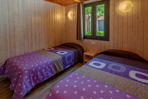 布拉内斯莎莫尔露营地的小木屋内一间卧室,配有两张床