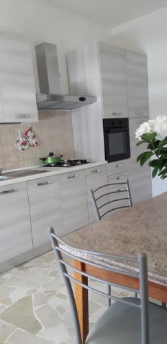 曼杜里亚Felline House的厨房配有白色橱柜和花瓶桌子