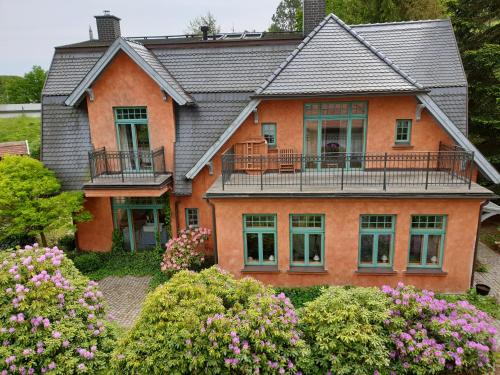 格拉尔-米里茨Ferienhaus am Wasserturm für 6 Erwachsene und 9 Kinder的一座大型橙色房子,设有阳台和鲜花