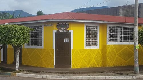JuayúaHostal Doña Mercedes的黄色和白色的建筑,有红色屋顶