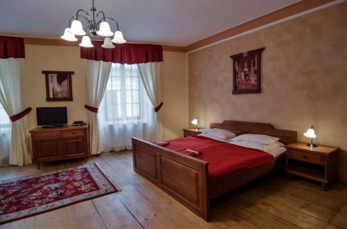 捷克克鲁姆洛夫Pension Pod Radnicí的一间卧室配有一张带红色毯子的大床