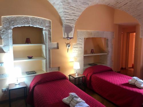 马丁纳弗兰卡B&B Nel Centro Storico的红色床单的客房内的两张床