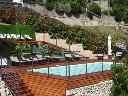 马尔切西内Appartamenti Tasel with heated Pool的一个带椅子的木制甲板和游泳池