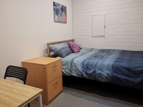 珀斯Quokka Backpackers Hostel Perth - note - Valid passport required to check in的一间卧室配有一张床、梳妆台和桌子