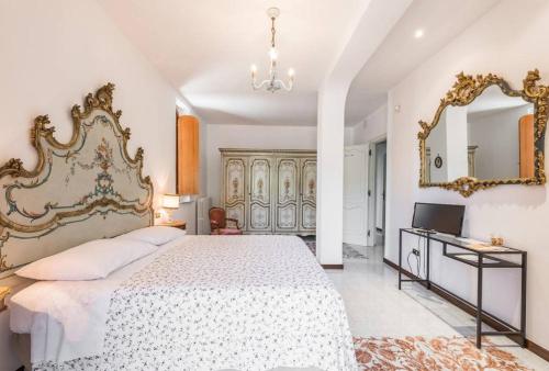 特拉尼Villa Mary的一间卧室配有一张大床和镜子