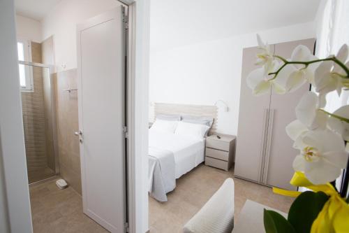 托雷圣乔万尼乌Villa Milù的卧室配有白色的床和镜子