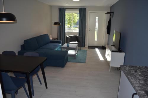 莱达尔绥里Einemo Apartments的客厅配有蓝色的沙发和桌子