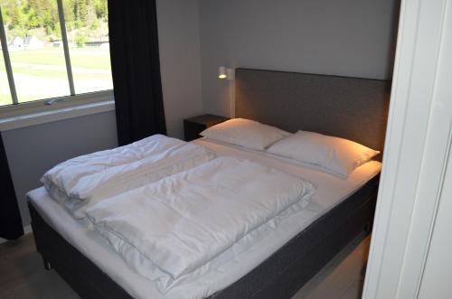 莱达尔绥里Einemo Apartments的卧室内的一张带白色床单和枕头的床