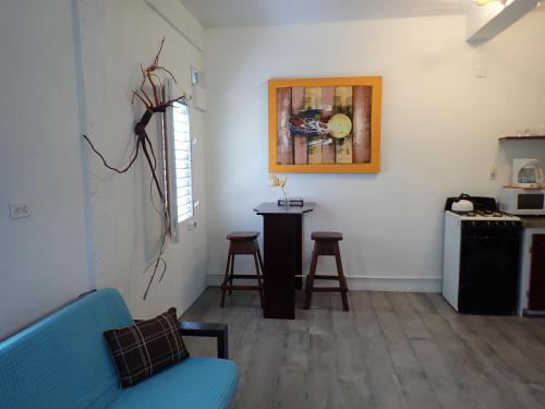 玛雅湾Simberts Apartments的客厅配有蓝色的沙发和桌子