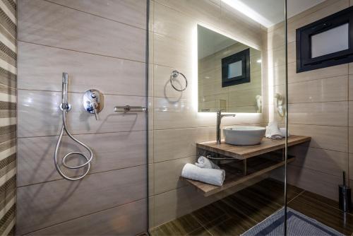 蒂锡利维ABATON Luxury Resort的一间带玻璃淋浴间和水槽的浴室