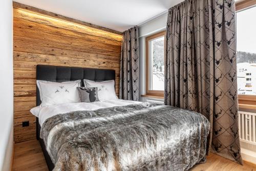 达沃斯Unique Alpic style apartment in the heart of Davos的一间卧室设有一张大床和木墙