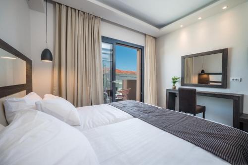 蒂锡利维ABATON Luxury Resort的配有一张床、一张书桌和一扇窗户的酒店客房