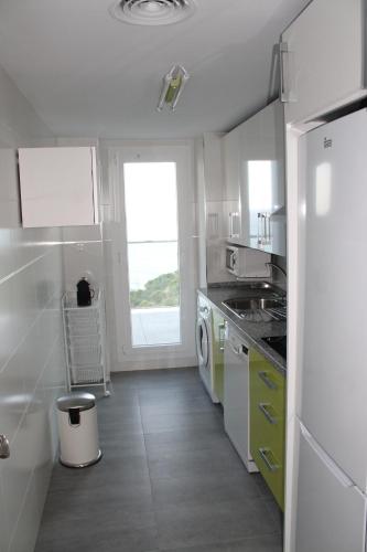 阿尔姆尼卡Dúplex playa Cabria的白色的厨房配有水槽和洗碗机