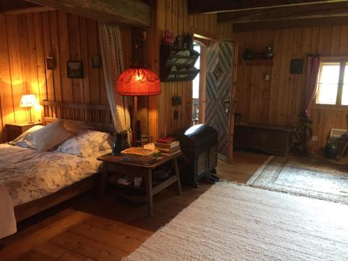 雷丹尼茨恩Cozy Log Cabin near Faaker See的一间卧室配有一张床和一张带台灯的桌子