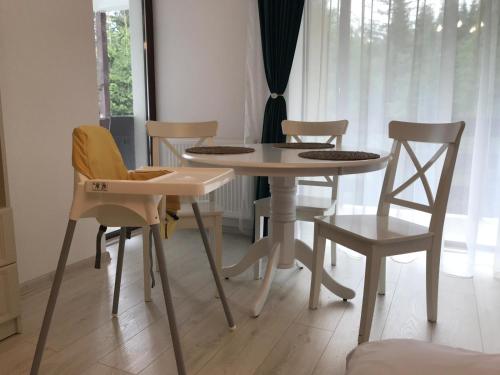 普雷代亚尔Studio 16 Predeal的窗户客房内的白色桌椅