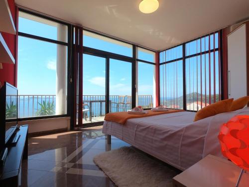 米利尼拉佩里亚公寓的一间卧室设有床铺和大型玻璃窗