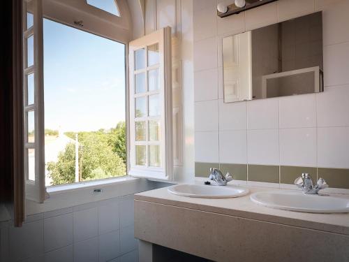 马尔旺火车站旅馆的一间带两个盥洗盆和窗户的浴室