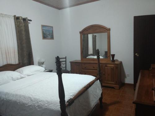 Faja GrandePandora的一间卧室配有一张床、梳妆台和镜子