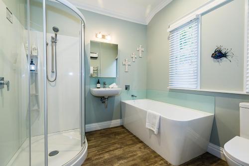 北哈夫洛克Deco Villa的带淋浴、浴缸和盥洗盆的浴室