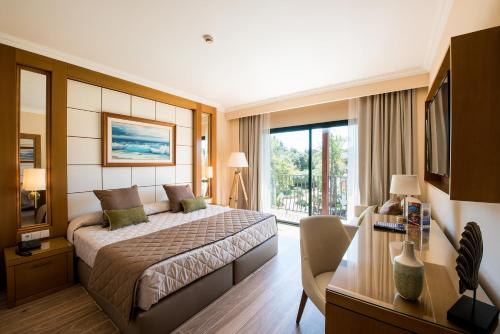萨洛PortAventura Hotel PortAventura - Includes PortAventura Park Tickets的配有一张床和一张书桌的酒店客房