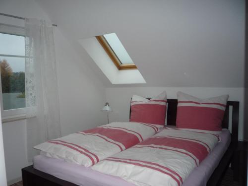 岑平Haus Vineta Wohnung 8的一间卧室配有红色和白色枕头的床
