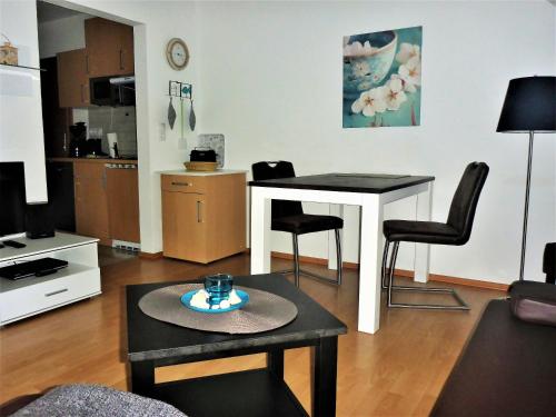 岑平Haus Vineta Wohnung 8的客厅配有桌子和两把椅子