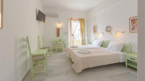 纳克索乔拉Hotel Sphinx的白色的客房配有两张床和电视。