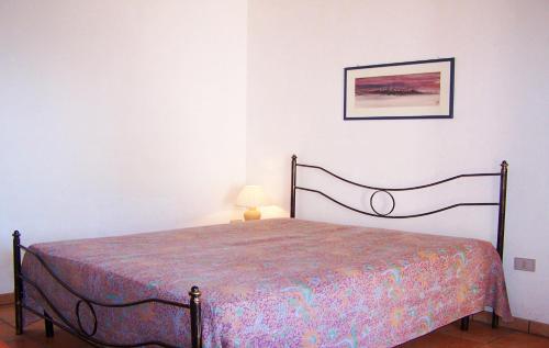 帕图Trullo Salentino的卧室配有一张床,墙上挂着一幅画
