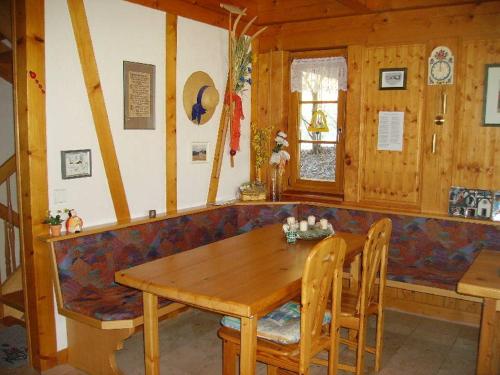 黑林山区克尼格斯费尔德Am Neuhausbauernhof的一间带木桌和沙发的用餐室