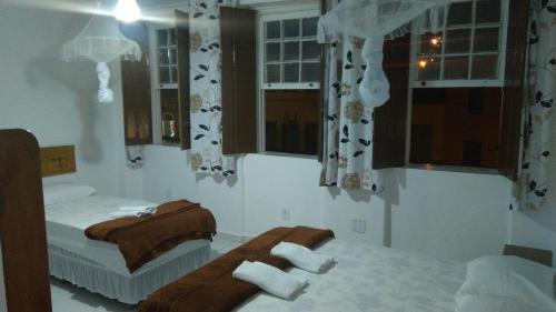 穆库热O Pouso Sobrado的一间卧室设有两张床,窗户配有毛巾