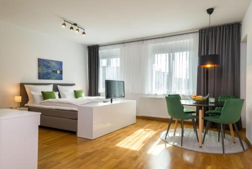 菲拉赫City Appartements Villach的卧室配有一张床和一张桌子及椅子