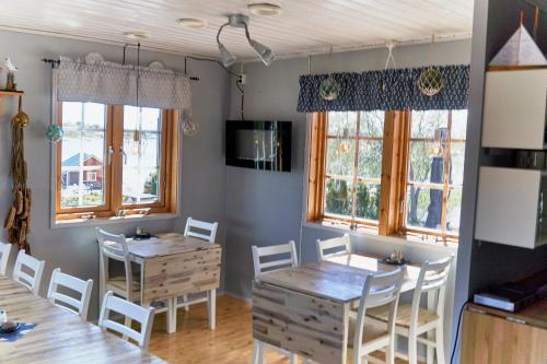 KumlingeKumlinge Stugor的用餐室设有2张桌子和椅子以及窗户。