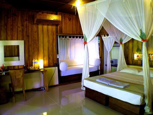 布纳肯布纳肯恰恰自然度假酒店的一间卧室设有两张床,窗户配有窗帘