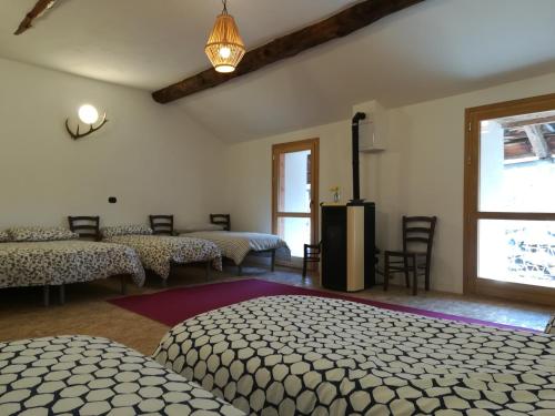 SalabertanoCantina Alpina的客房设有两张床、椅子和窗户。