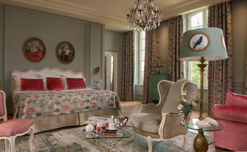 贝叶拉勒别墅酒店的一间卧室配有一张床、椅子和吊灯