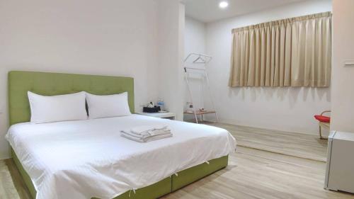 台南NO.14的一间卧室配有一张大床和绿色床头板