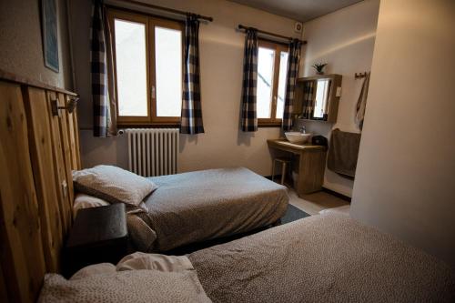 蒙乃第耶-勒潘GITE LES GUIBERTES的小房间设有两张床和盥洗盆