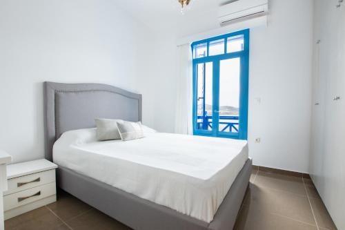 卡尔帕索斯Poseidon Luxury Apartment的白色的卧室设有床和窗户