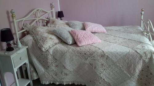 Saint-Martin-Saint-FirminLe Petit Château的一张白色的床,上面有粉红色枕头