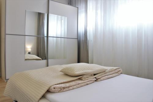茨魏布肯Ferienwohnung的白色卧室配有一张带镜子的床