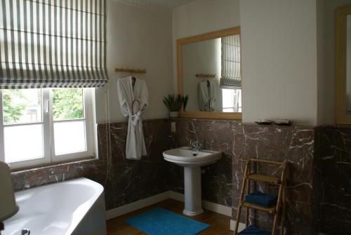 克诺克－海斯特Au Coeur de la Famille的带浴缸、水槽和镜子的浴室