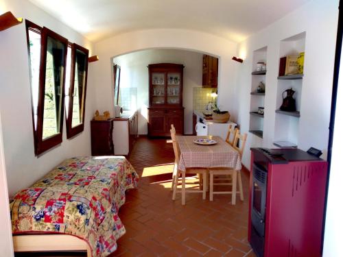 斯卡尔利诺ROMANTICA TOSCANA的一间卧室配有一张床铺和一张桌子,还设有一间厨房