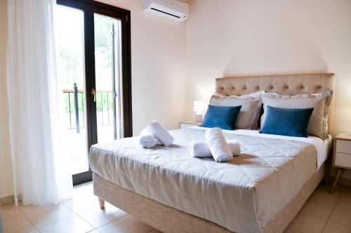 克里奥斯Anemi Superior Deluxe Suite的卧室配有带蓝色枕头的大型白色床