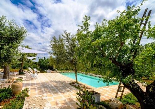 卡斯特拉纳格罗泰Masseria Montefieno的一座树木繁茂的庭院内的游泳池