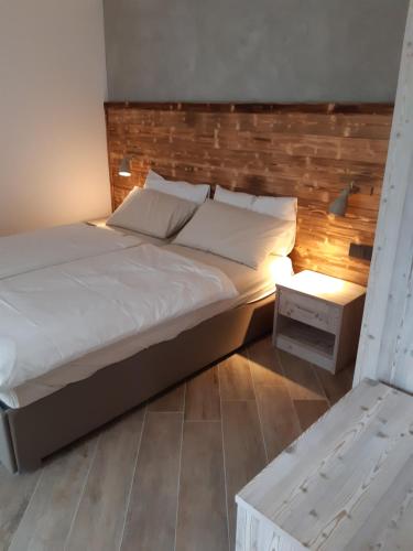 莱德罗Ledro Nest的一间卧室配有一张大床和木制床头板