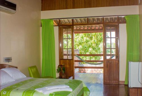 YurimaguasHotel Rio Huallaga的一间卧室设有一张床和一个滑动玻璃门