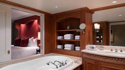 温哥华Wedgewood Hotel & Spa - Relais & Chateaux的带浴缸的浴室和1间带1张床的卧室