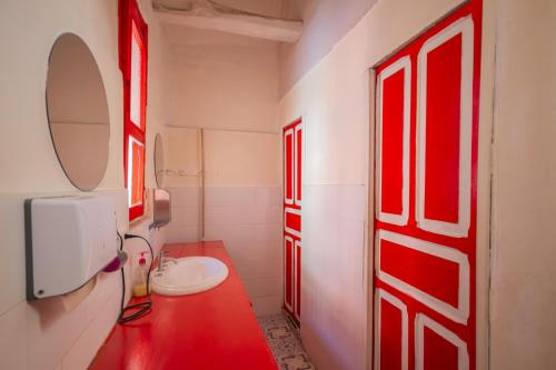 波哥大博坦尼科旅舍的浴室设有红色的门、水槽和镜子